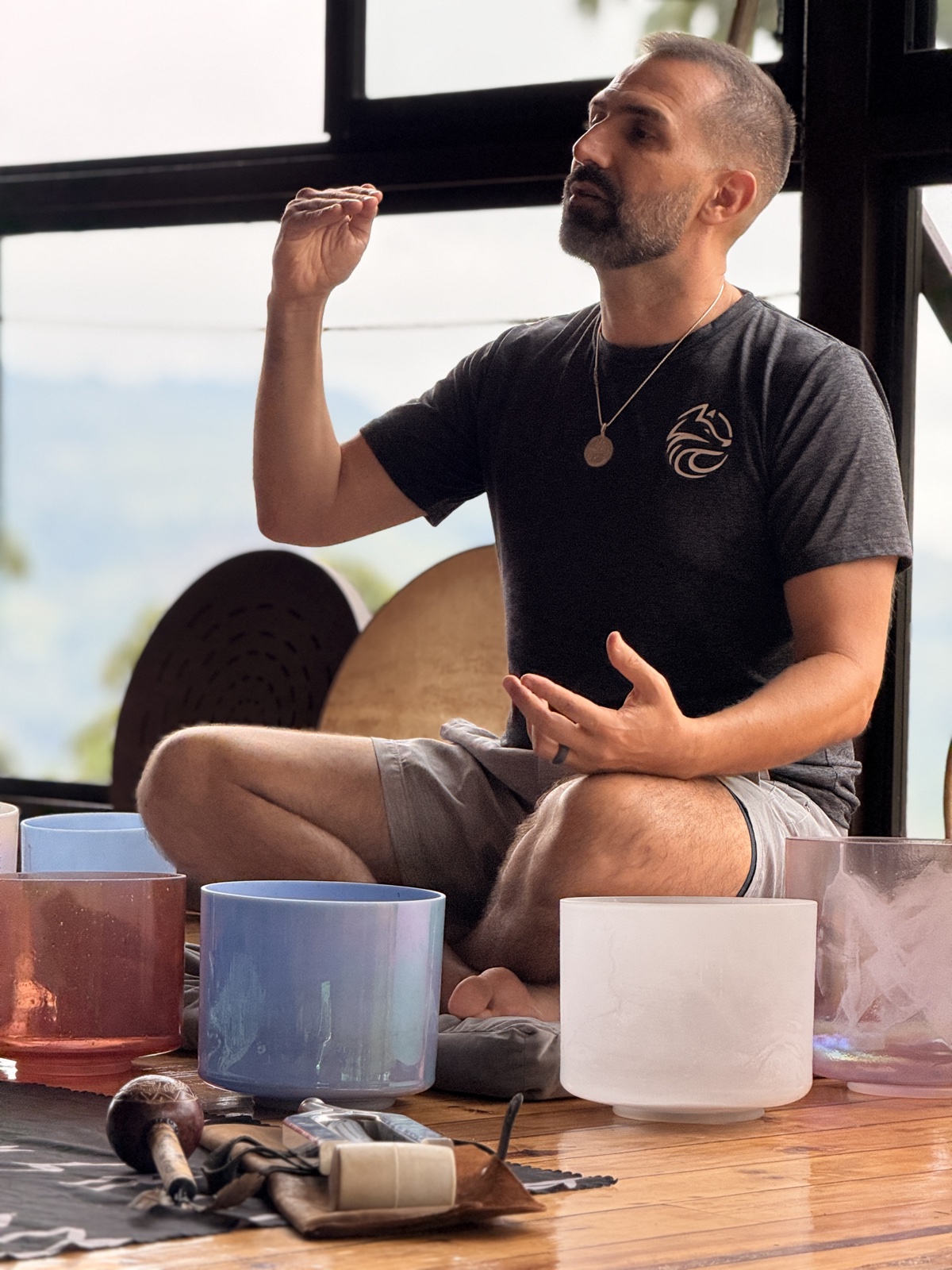 Facilitator Nano seated with singing bowls during a retreat session