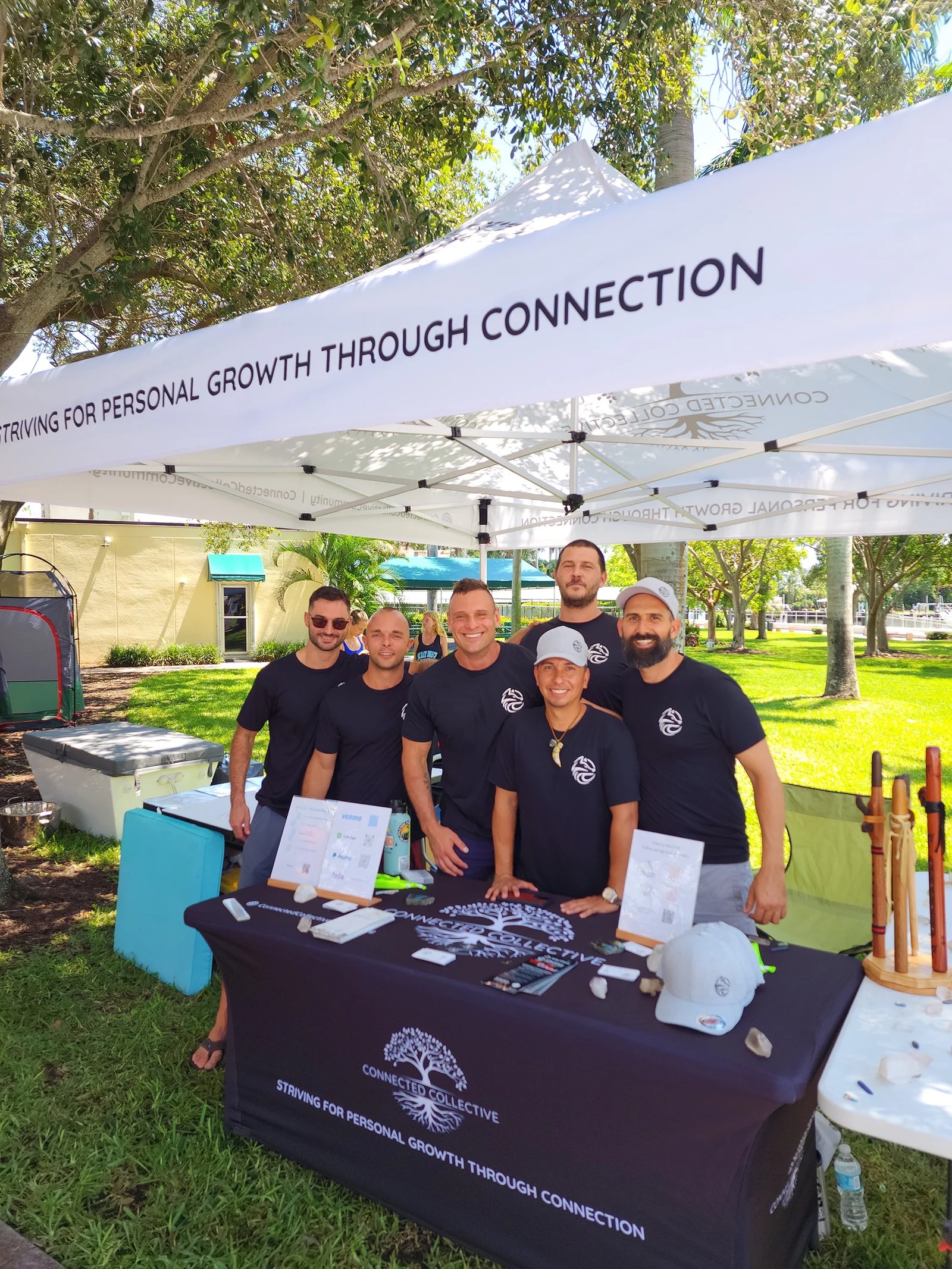Brotherhood founders at an outdoor community event booth, striving for personal growth through connection